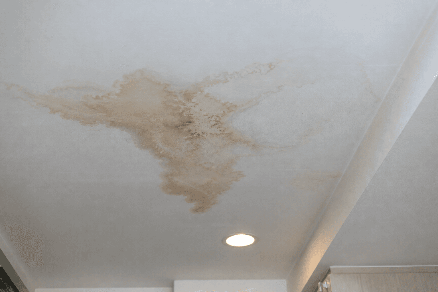 Ceiling water stain from an upstairs unit leak in a Singapore home